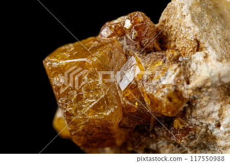 Macro stone Grossular mineral on a black background 117550988