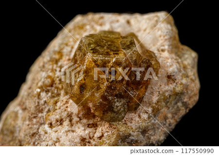 Macro stone Grossular mineral on a black background Macro stone Grossular mineral on a black background 117550990