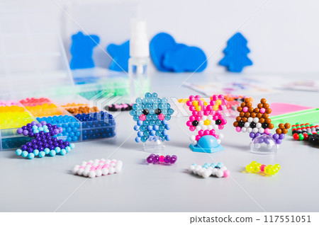 Children's toys made of aqua beads and a set for making on the table 117551051