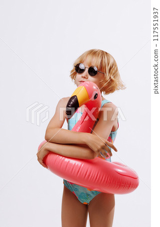 Child with inflatable duck ring on blue background with copy space. Child with inflatable duck ring on blue background with copy space. 117551937
