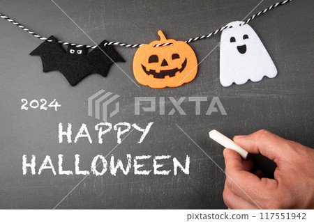 Happy Halloween. Text and holiday decorations on a black chalkboard background 117551942