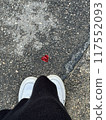 A human being stands close to a vibrant red heart painted on the ground 117552093