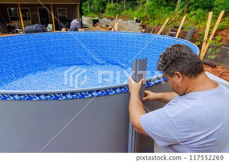 Worker installation metal frame of above ground pool is underway 117552269