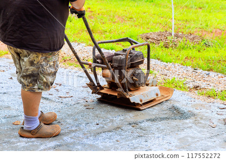 Vibratory tamping machine compacts sand during construction of swimming pool platform 117552272