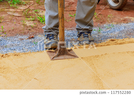 Sand tamping with worker uses manual rammer Sand tamping with worker uses manual rammer 117552280