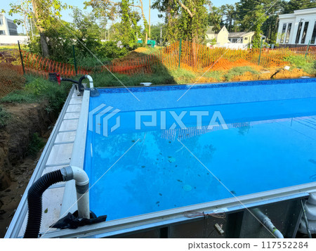 Swimming ground pool construction in backyard of near house 117552284