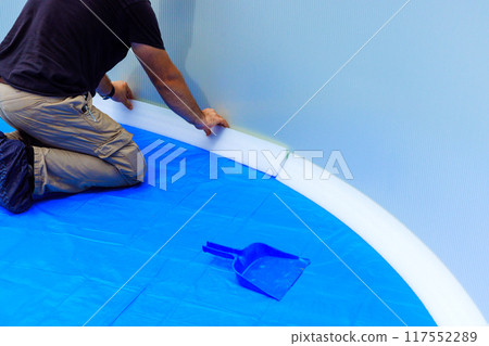 An employee installing durable foam construction protects the pool liner at ground pool 117552289