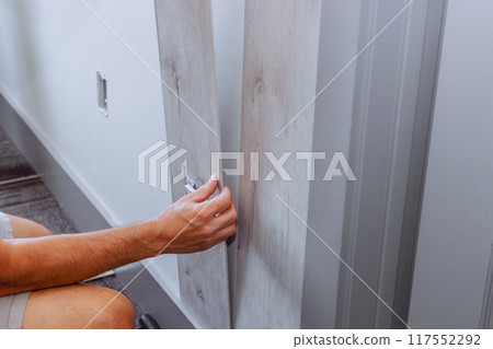 Installation of laminated panels on wall in room house during reconstruction 117552292