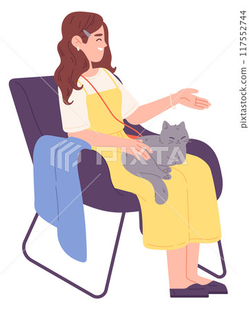 Young sit in soft armchair and play with cat 117552744