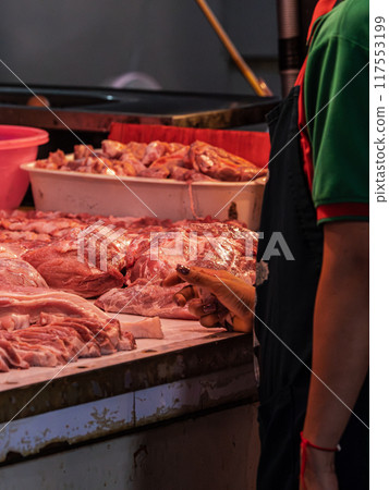 Butcher Selecting Meat at Market Stall Butcher Selecting Meat at Market Stall 117553199