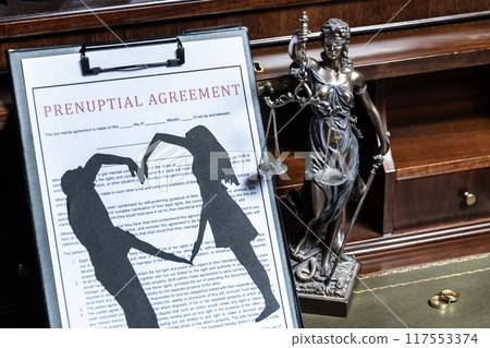 A prenuptial agreement with a silhouette of a couple on a clipboard, with the statue of justice in the background, representing the legalities of marriage. A prenuptial agreement with a silhouette of a couple on a clipboard, with the statue of justice in the background, representing the legalities of marriage. 117553374
