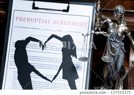 A prenuptial agreement with a silhouette of a couple on a clipboard, with the statue of justice in the background, representing the legalities of marriage. A prenuptial agreement with a silhouette of a couple on a clipboard, with the statue of justice in the background, representing the legalities of marriage. 117553375