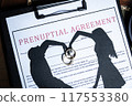 A prenuptial agreement with a silhouette of a couple and wedding rings, symbolizing marital contracts and legal preparation. 117553380