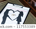 A prenuptial agreement with a silhouette of a couple and wedding rings, symbolizing marital contracts and legal preparation. 117553389