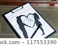 A prenuptial agreement with a silhouette of a couple and wedding rings, symbolizing marital contracts and legal preparation. 117553390