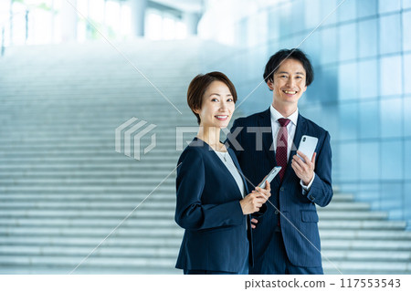 Male and female employees with smartphones Business image 117553543