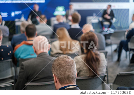 Audience attending business seminar with speakers on stage Audience attending business seminar with speakers on stage 117553628