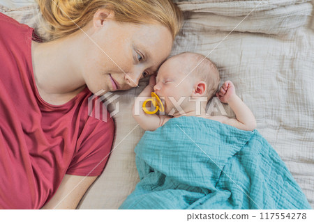 Mom with newborn baby relaxing on the sofa at home. This tender moment highlights the bond between mother and child in a comfortable and loving family environment Mom with newborn baby relaxing on the sofa at home. This tender moment highlights the bond between mother and child in a comfortable and loving family environment 117554278