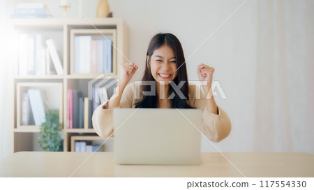 Funny euphoric young asian woman celebrating winning 117554330