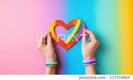 A person holding a heart shaped paper on rainbow colored background, AI 117554664