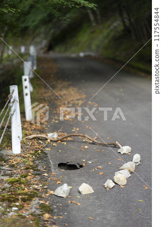 Road with sunken and potholes 117554844