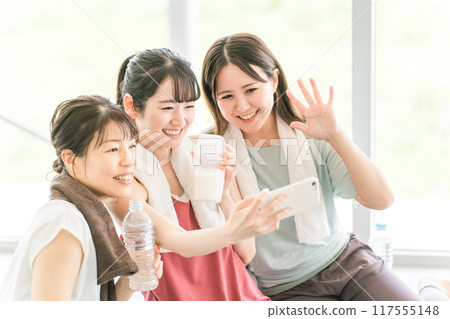 女性在體育館瑜伽課休息時用智能手機拍照 女性在體育館瑜伽課休息時用智能手機拍照 117555148