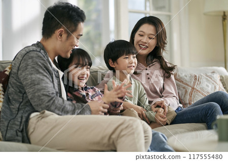 young asian family with two children watching tv together at home young asian family with two children watching tv together at home 117555480