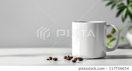 A white mug sits on a white table with coffee beans scattered around it 117556654