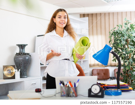 Young female office worker with rolled-up mat Young female office worker with rolled-up mat 117557190