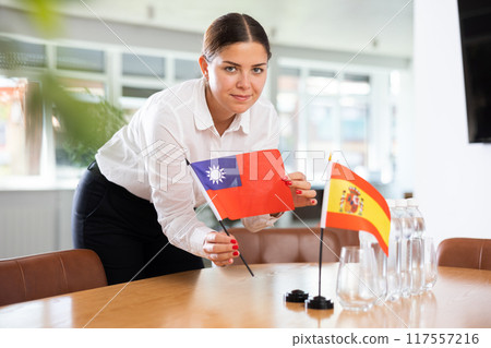 Young lady sets miniatures flags of Spain and Taiwan before international negotiations Young lady sets miniatures flags of Spain and Taiwan before international negotiations 117557216