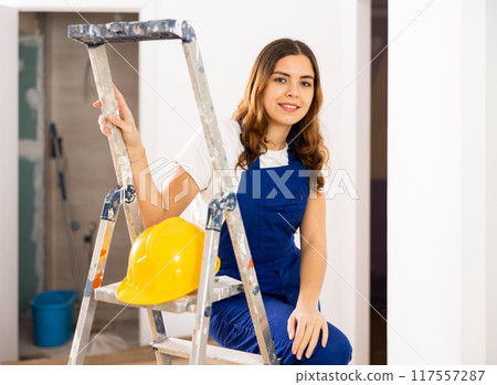 Portrait of young woman builder standing in apartment 117557287