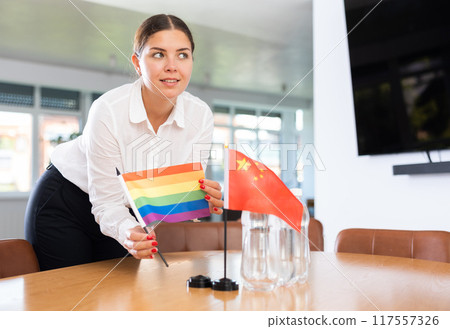 Young lady sets miniatures flags of China and LGBT before international negotiations Young lady sets miniatures flags of China and LGBT before international negotiations 117557326