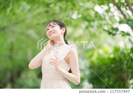 A woman walking in the park and wiping off sweat 117557947