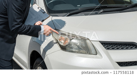 Salesman/appraiser using a checklist to assess and estimate a car 117558118