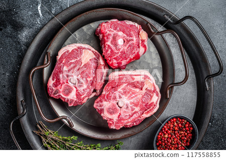 Raw lamb neck meat with bone on a steel tray. Black background. Top view 117558855