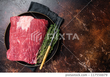 Fresh beef brisket, raw meat with herbs. Dark background. Top view. Copy space 117558879