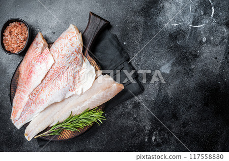 Fresh Raw red perch fillet, Snapper fish on a wooden board. Wooden background. Top view. Copy space 117558880