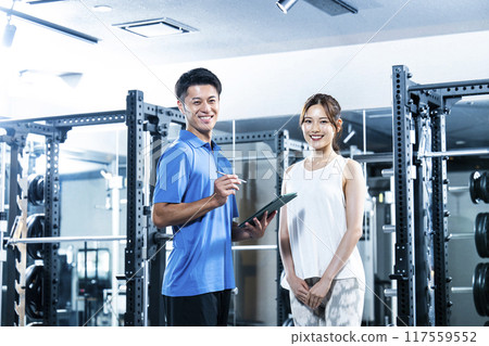 Male and female personal trainers looking at camera Male and female personal trainers looking at camera 117559552