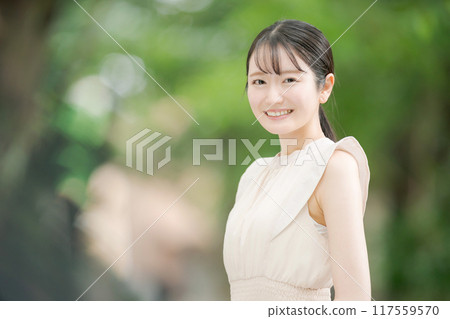 一名 20 多歲的女性在公園裡微笑 117559570