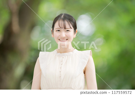 一名 20 多歲的女性在公園裡微笑 117559572