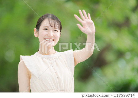 Woman waving in the park 117559714