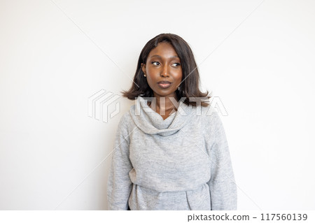 A woman is pictured wearing a stylish gray sweater, set against a plain white background 117560139
