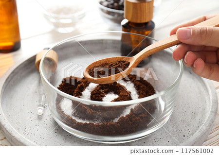Coffee scrub for the body, in a plate with care products, on a white background. Coffee scrub for the body, in a plate with care products, on a white background. 117561002