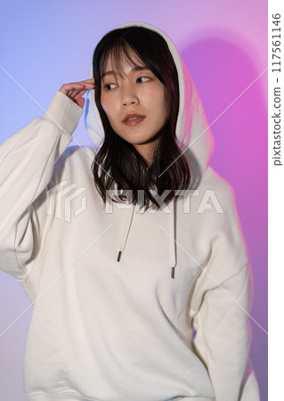 一位身穿白色連帽衫、頭戴兜帽的年輕女子的肖像 117561146