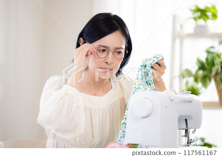 Hobby: Middle-aged woman sewing with a sewing machine 117561167