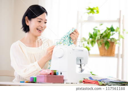 Hobby: Middle-aged woman sewing with a sewing machine 117561188