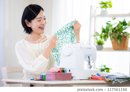 Hobby: Middle-aged woman sewing with a sewing machine 117561198