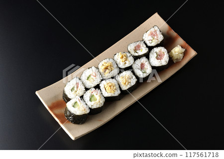 Assorted sushi rolls photographed against a black background Assorted sushi rolls photographed against a black background 117561718