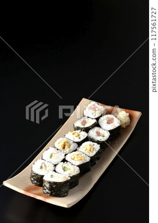 Assorted sushi rolls photographed against a black background Assorted sushi rolls photographed against a black background 117561727