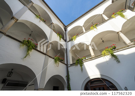 flowers on the balcony inside a typical courtyard between old buildings in Linz, Austruia 117562320